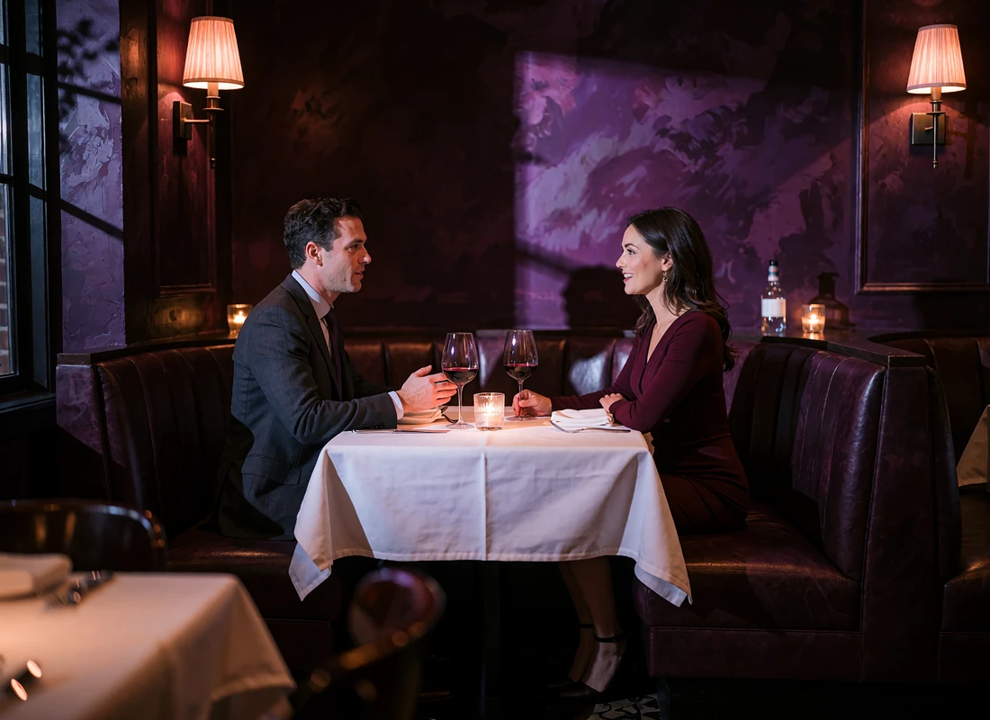 Couple seated in a corner booth at a dark-panelled Dallas steakhouse sharing wine and conversation