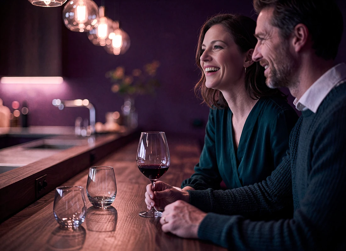 Couple seated at a walnut chef's counter in a Denver restaurant, the woman in a teal dress laughing with a wine glass in hand